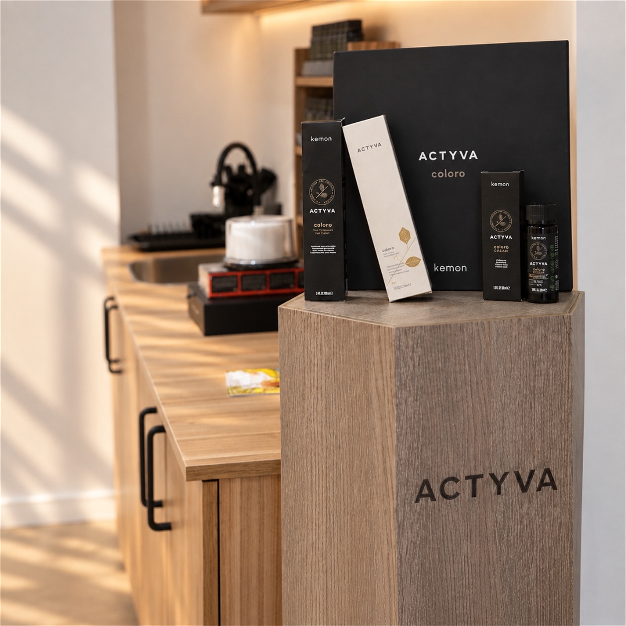 Cajas de color capilar Actyva Coloro sobre una columna expositora de madera